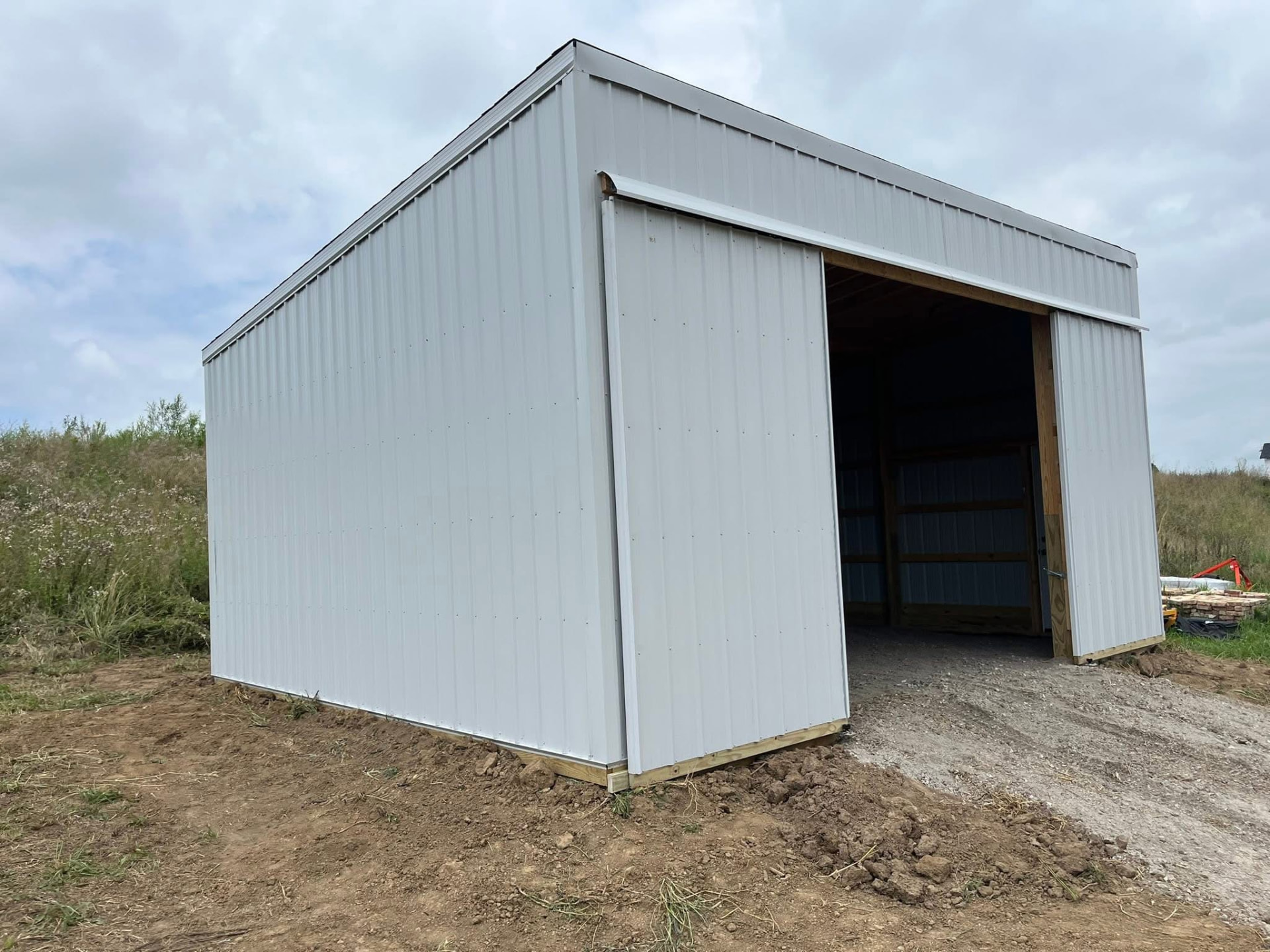 White metal pole barn with sliding door